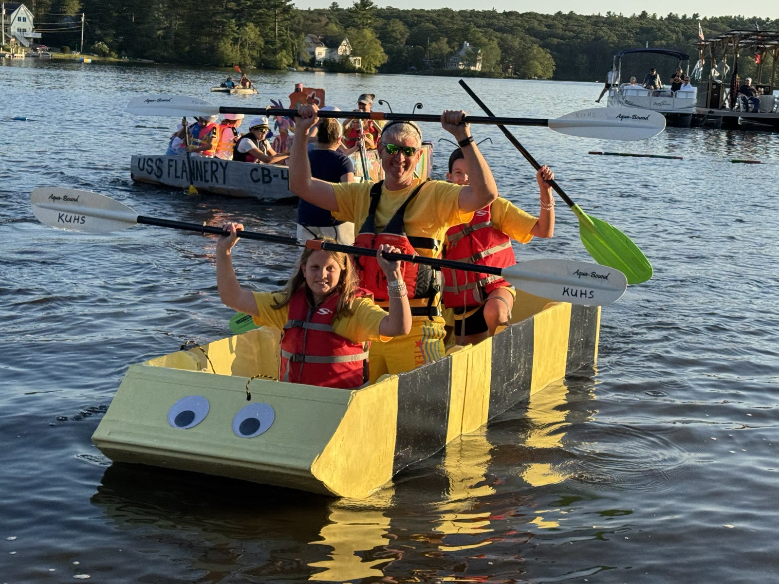 The BumbleMcBees afloat with its crew paddling at the 2025 cardboard boat race