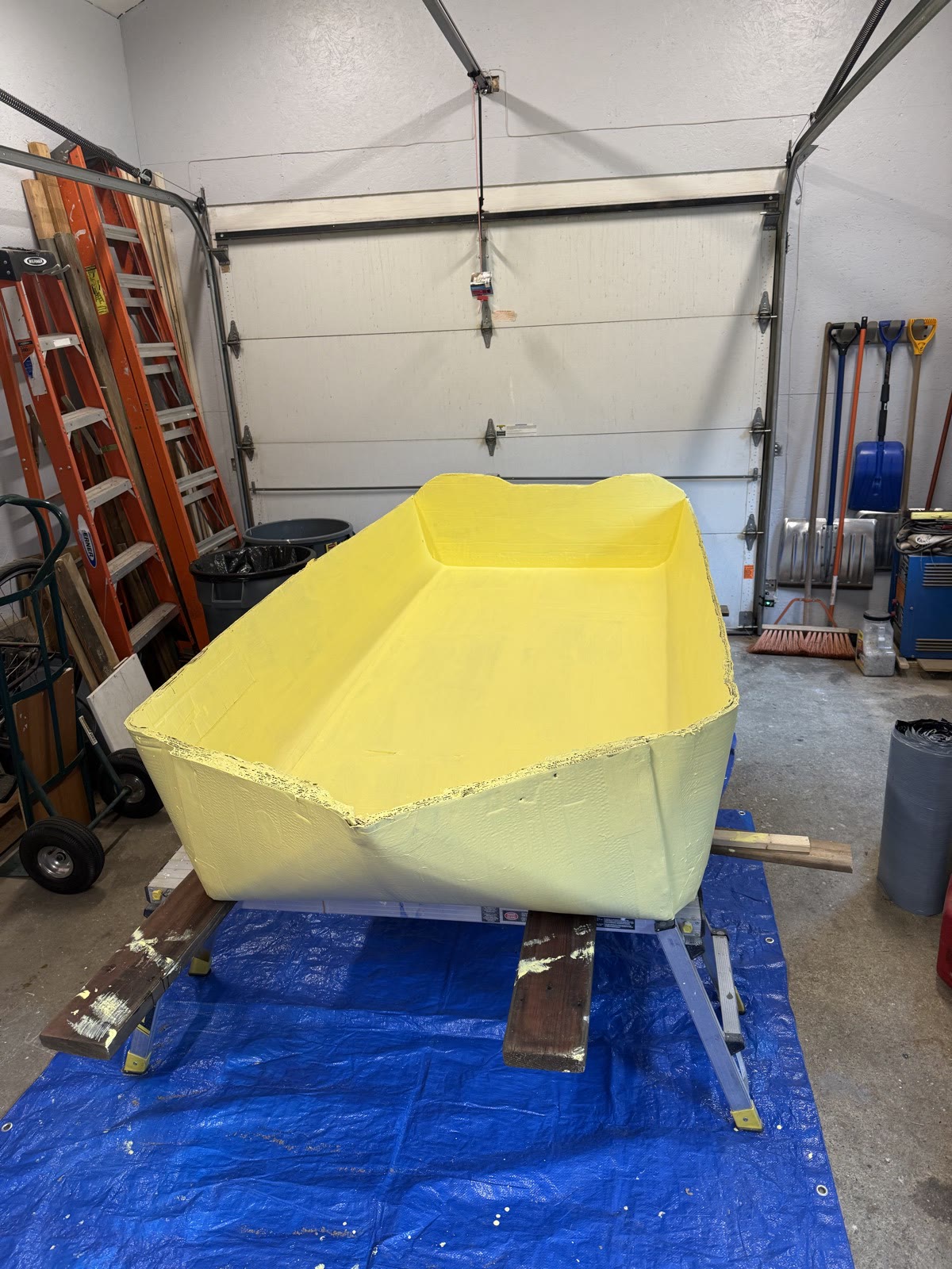 The yellow hull of The Unsinkable Luau during final construction in Captain Dan’s workshop